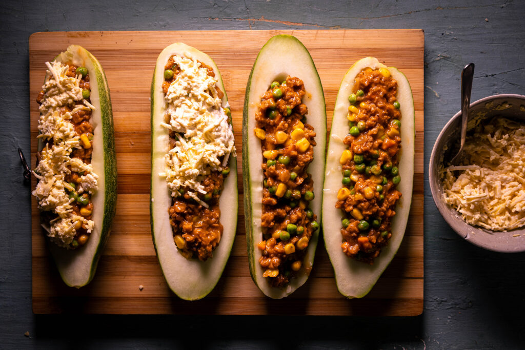Das vegane Käse-Sahne-Gemisch wird auf die gefüllten Schmorgurken verteilt.