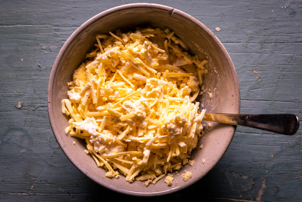 Vegane Sahne und Käse werden in einer Schüssel verrührt.