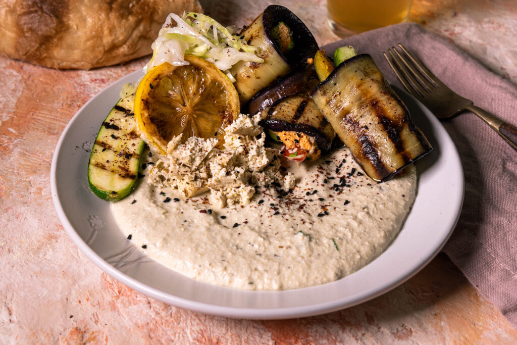 Veganer Auberginen-Schafskäse-Dip, Auberginen-Veta-Creme auf einem Teller mit geröstetem Gemüse.