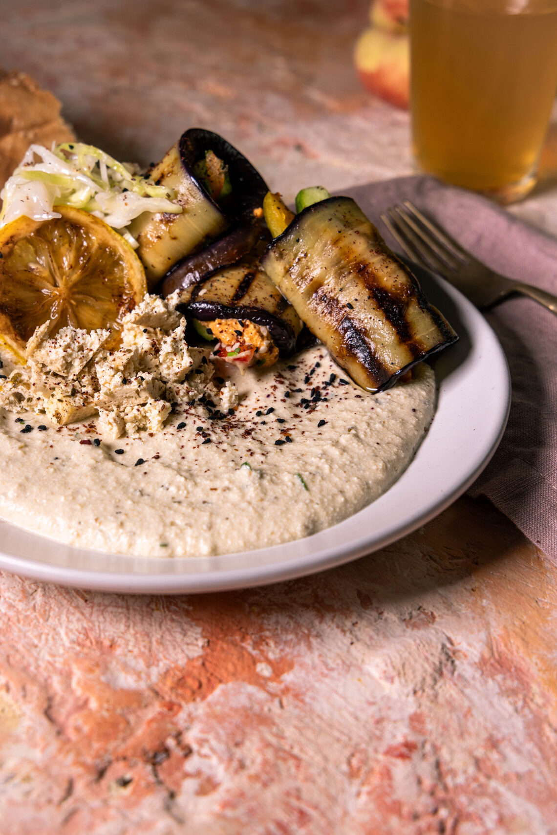 Veganer Auberginen-Schafskäse-Dip, Auberginen-Veta-Creme, mit verschiedenen Beilagen auf einem Teller.