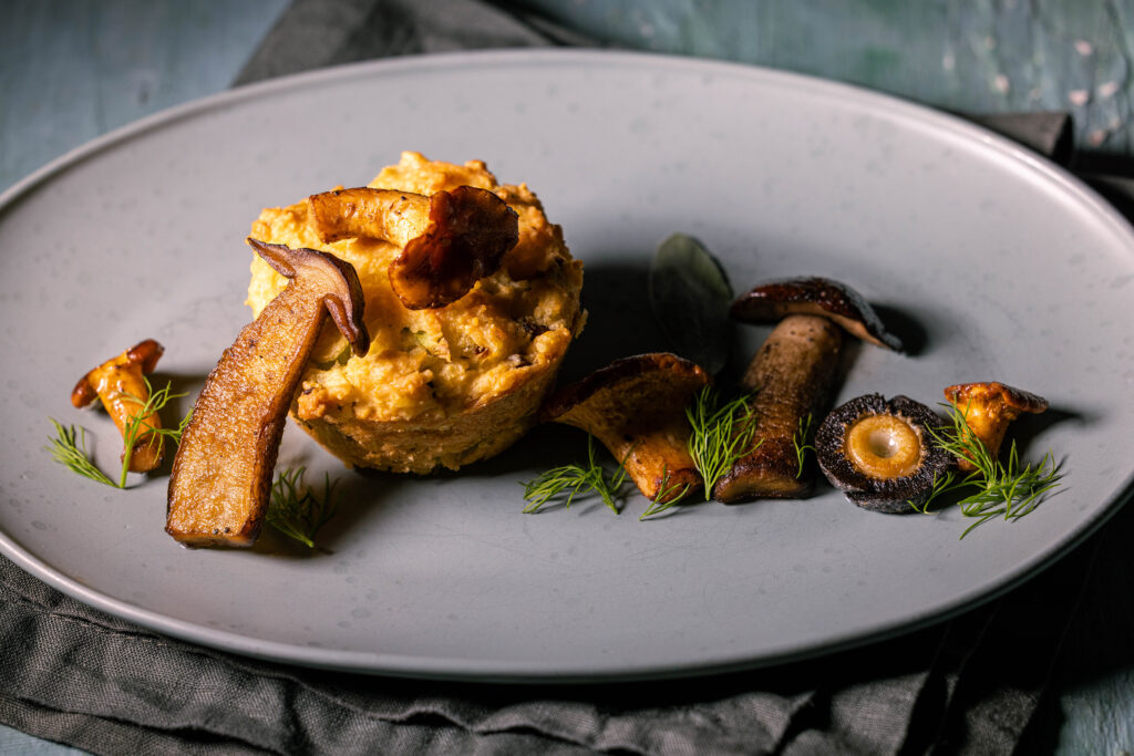 Herzhafte Pfifferling Mussinfs mit gebratenen Pilzen und frischen Kräutern.