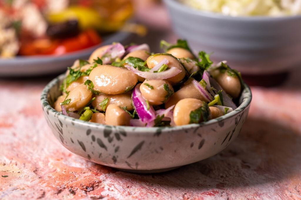 Türkischer Weiße Bohnensalat in einer kleinen grünen Schale.