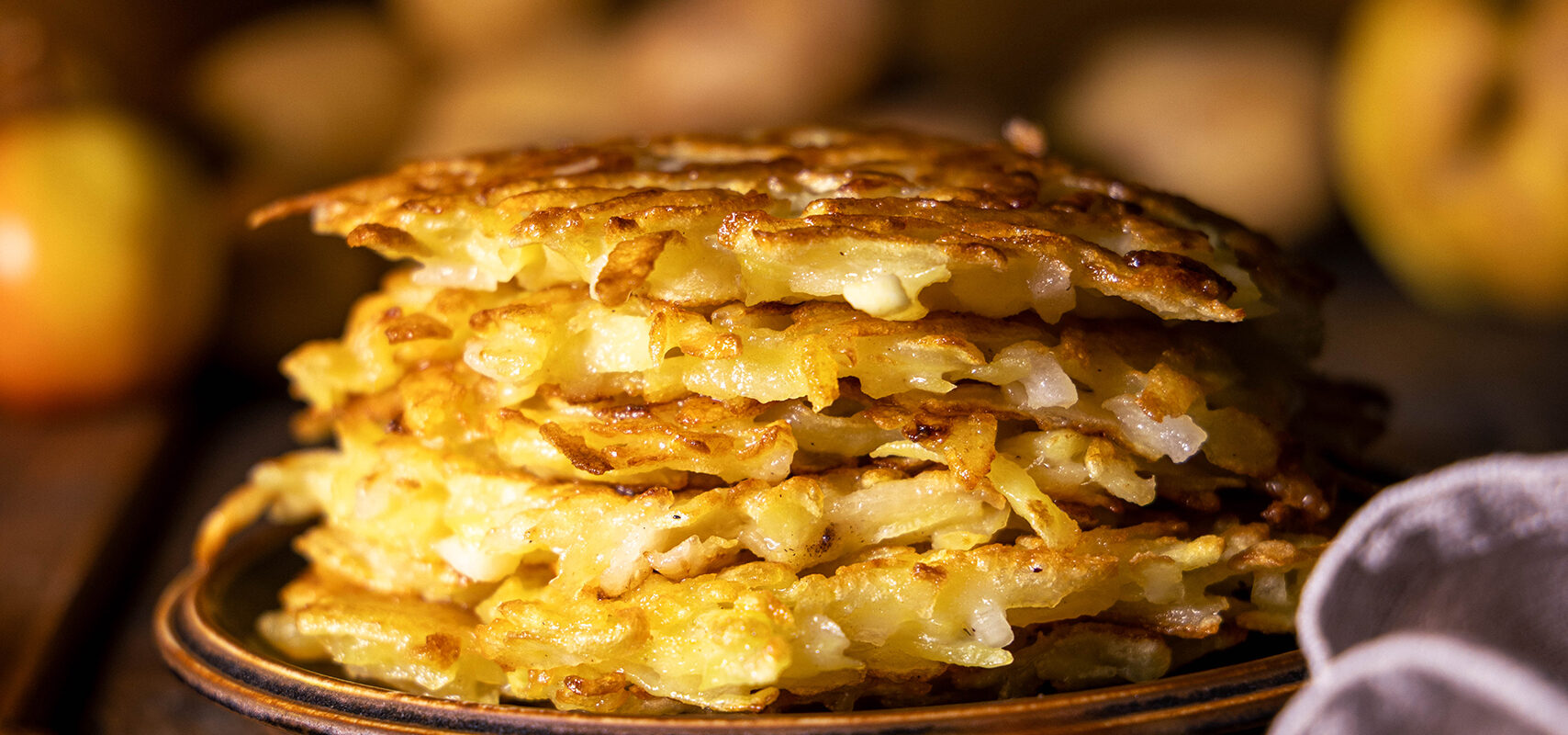 Kartoffelpuffer, vegan,auf einem Teller gestapelt.