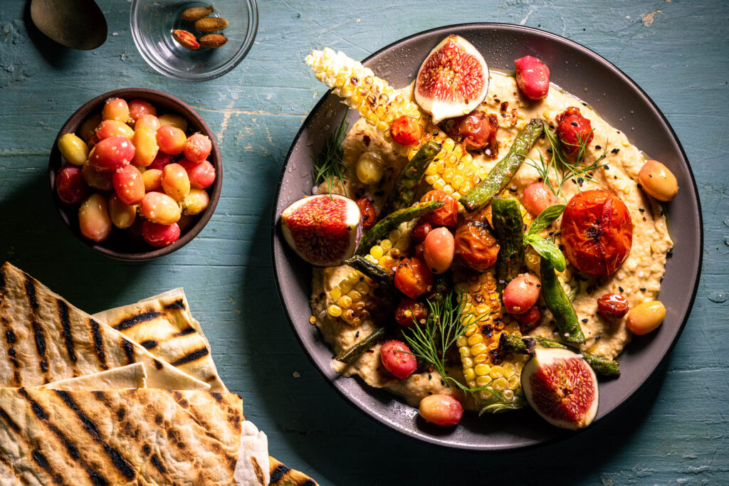 Kornelkirsch-Oliven zu Loaded Hummus mit gegrillten und gebratenem Gemüse.