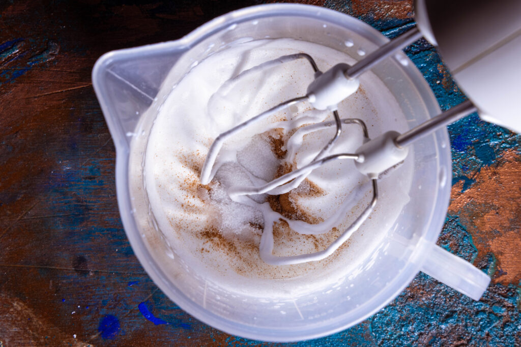 Vegane Sahne wird mit Zucker und Zimt aufgeschlagen.