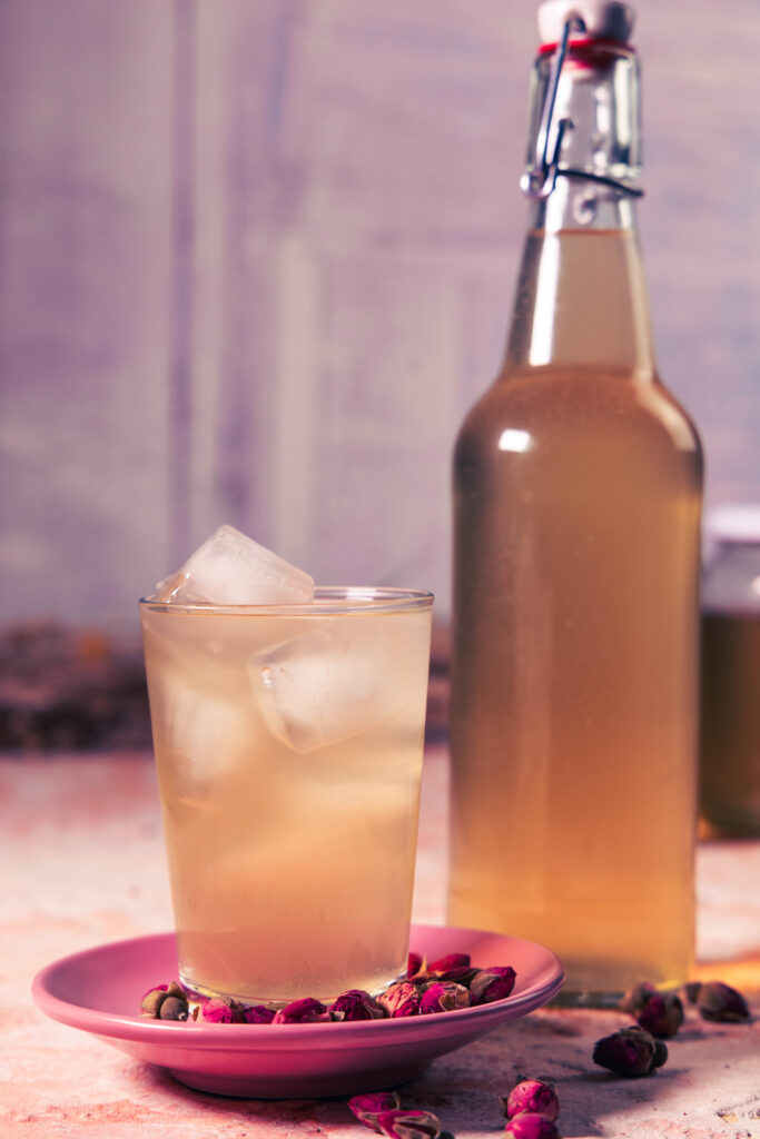 Rosen-Kombucha - in Flaschen und mit Eis in einem Glas.