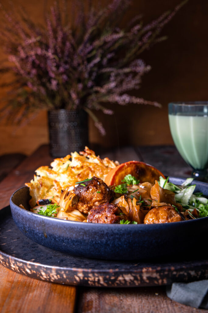 Schmorkohl mit veganen Hackbällchen. Dazu: Kartoffelpuffer als Beilage