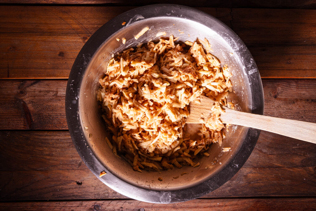 Eine Schüssel mit einer rohen Apfelmasse für Schwedische Apfeltorte.