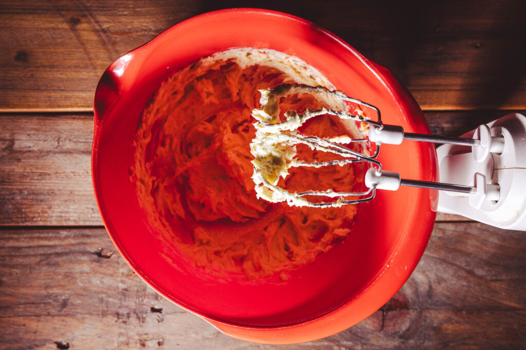 Vegane Butter, Zucker, Salz, Senfmehl und Pfeffer werden mit dem Mixer in einer großen Schüssel aufgeschlagen.