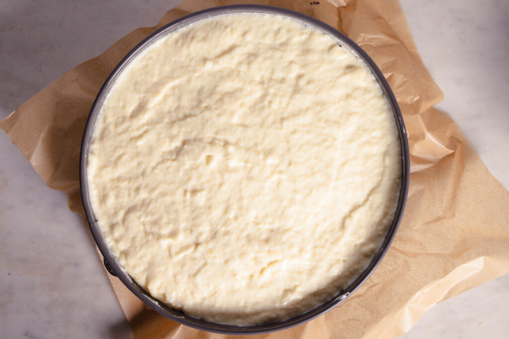 Eine vegane Käsehaube vor dem Backen auf einem Kuchen.