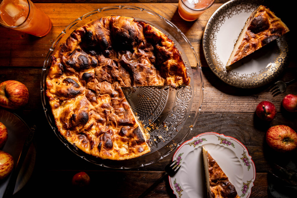 Bratapfelkäsekuchen von oben, zwei Stücke auf antiken Sammeltellern.