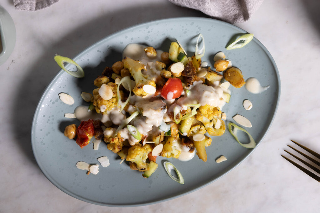 Würzig, schmackhaft gerösteter Blumenkohl, gepaart mit angebratenen Kichererbsen, saftigen Tomaten voller Umami, fruchtige Süße einbringenden Feigenstückchen und knackigen Gurken.