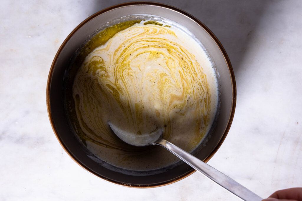 Joghurt-Tahini-Dressing wird in einer Schale verrührt.