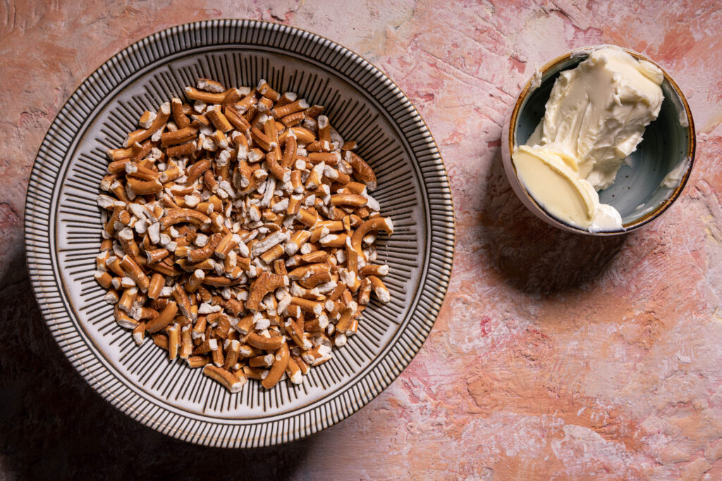 Zerbröselte Minibrezeln und vegane Butter in Schalen.