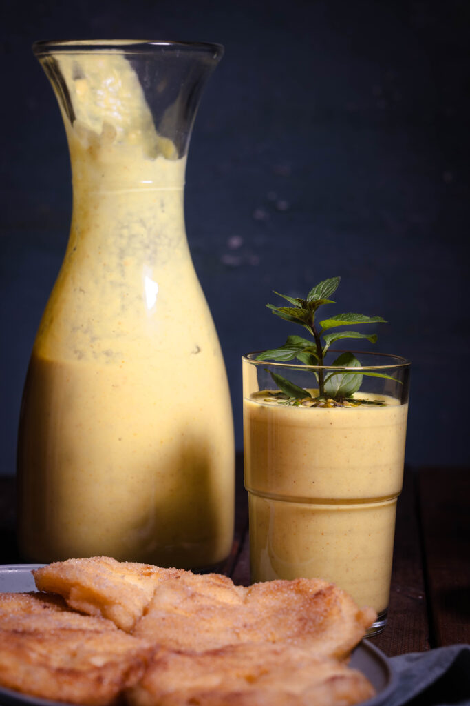 Vegane Quitten Lassi in einem Glas und in einer Karaffe.