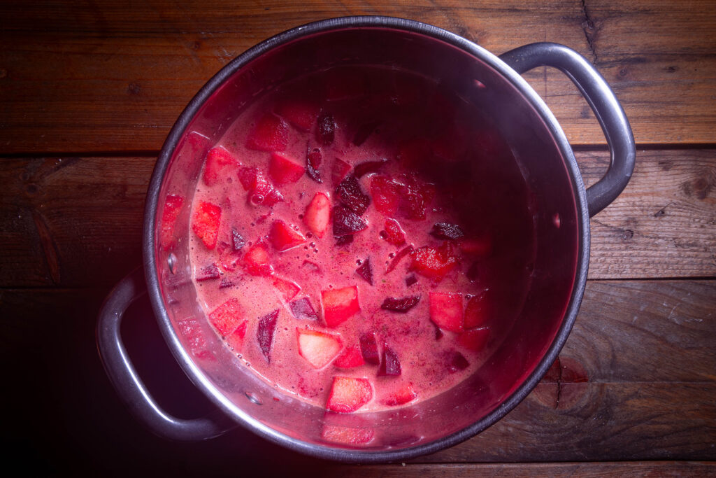 Rote-Beete-Apfel-Suppe wird in einem Kochtopf zubereitet.