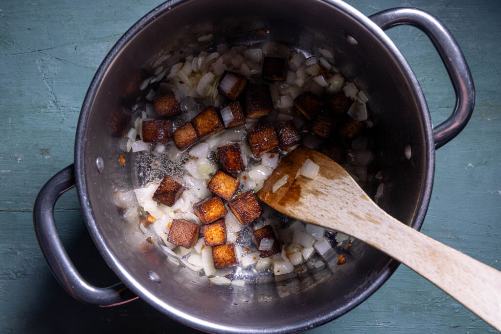 Zwiebeln und Räcuhertofu braten in Zwiebelschmalz in einem Kochtopf-
