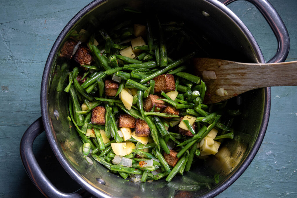 Grüne Bohnensuppe wird im Topf zubereitet.