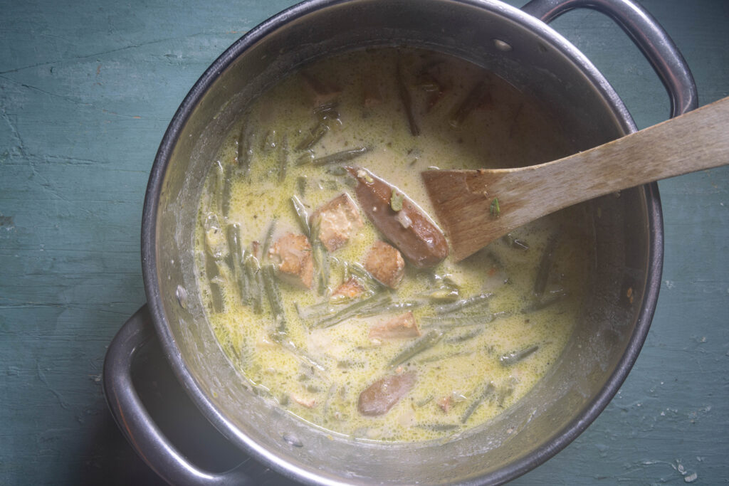 Schnippelbohnensuppe gart in einem Kochtopf.