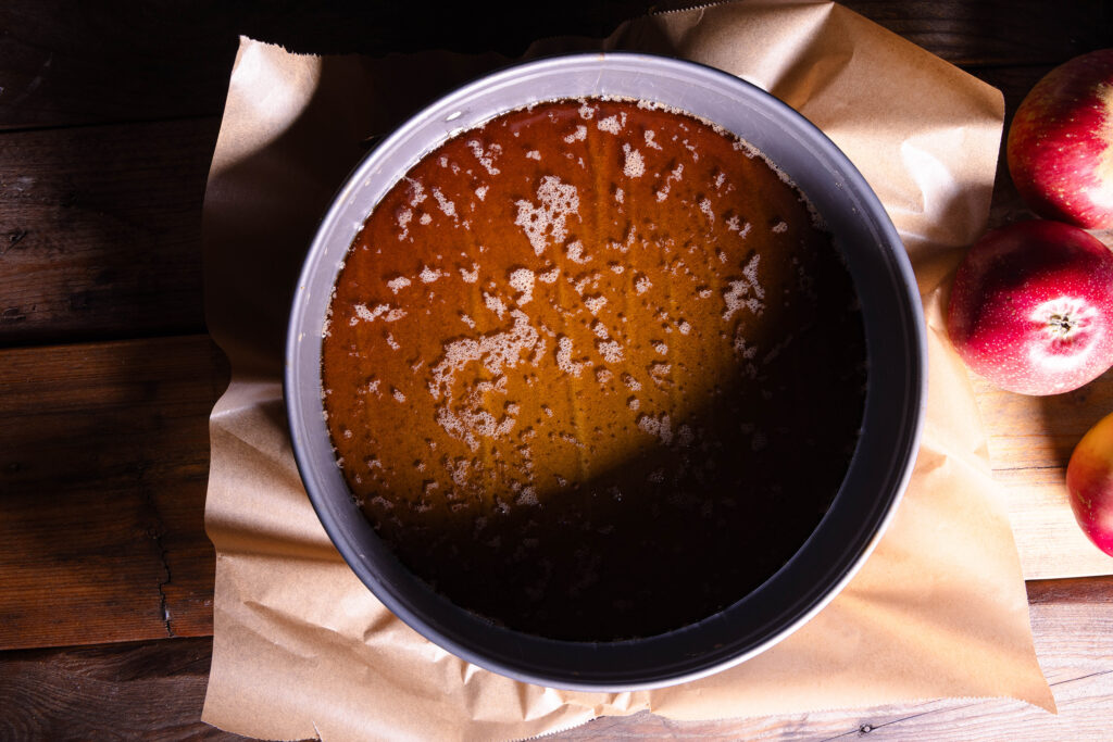 Cidre-Karamell-Sauce in einer mit Backpapier ausgelegten Springform.