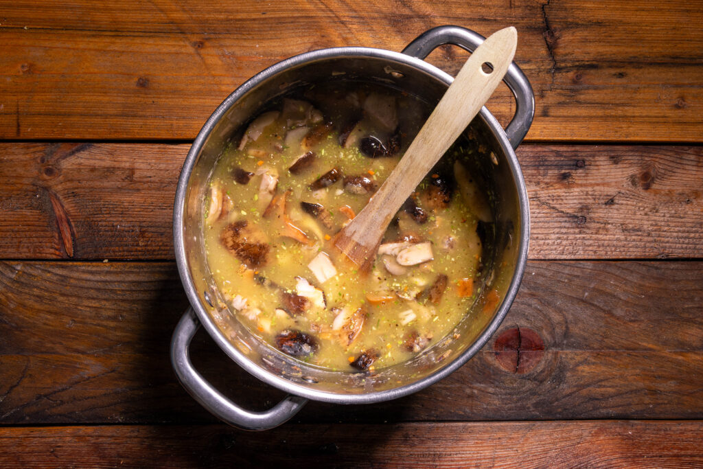 Eine Suppe aus Waldpilzen wird in einem Topf zubereitet.
