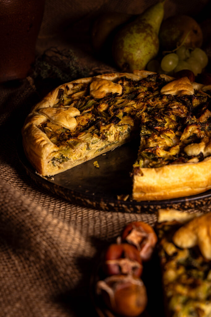Wirsingquiche, vegane mit Blätterteig, angeschnitten auf einem herbstlichen Teller.