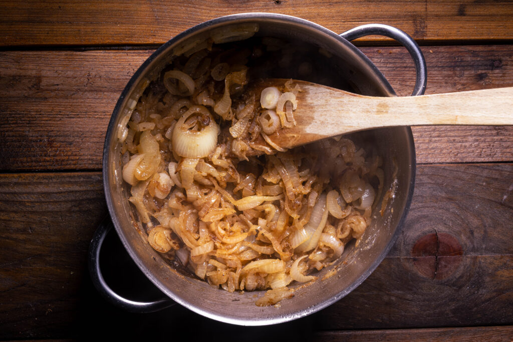 Mit Mehl bepuderte Zwiebeln braten in einem Kochtopf