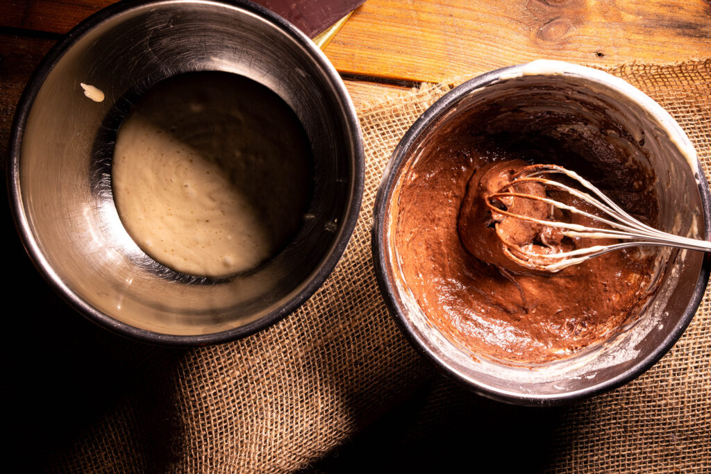 Veganer Rührteig in zwei Schüsseln, einer mit Kakao.