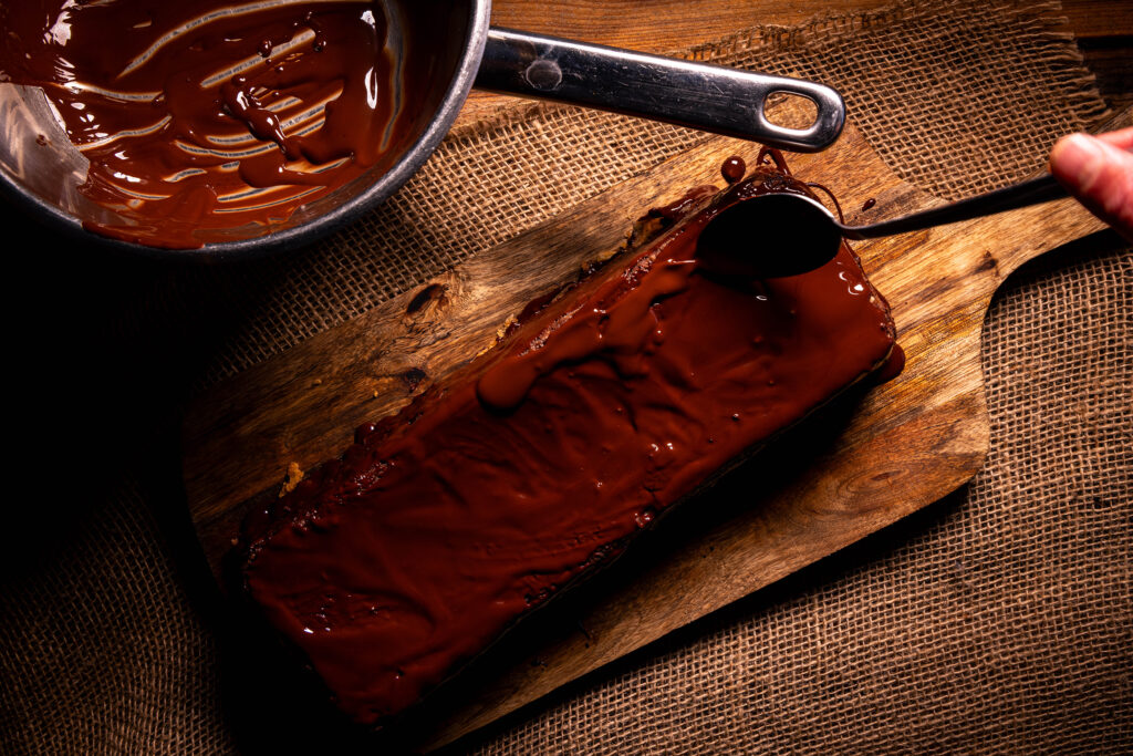Apfelmarmorkuchen wird mit geschmolzener Zartbitterschokolade glasiert.