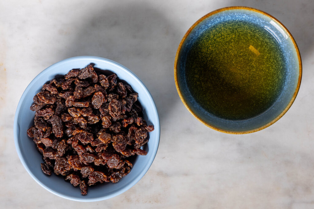 Eine Schale Rosinen und eine Schale Rum.