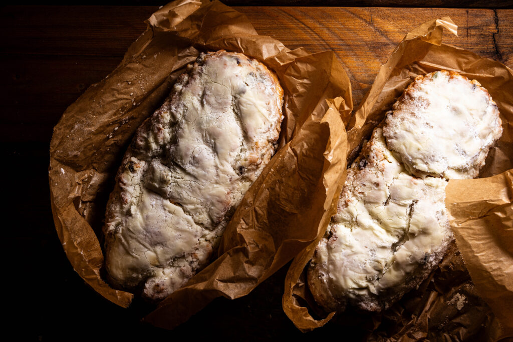 Zwei Stollen auf Backpapier, frisch ausgepackt.