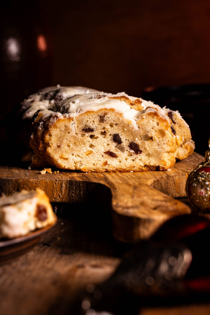 Veganer Christstollen, angeschnitten auf einem Holzbrett.