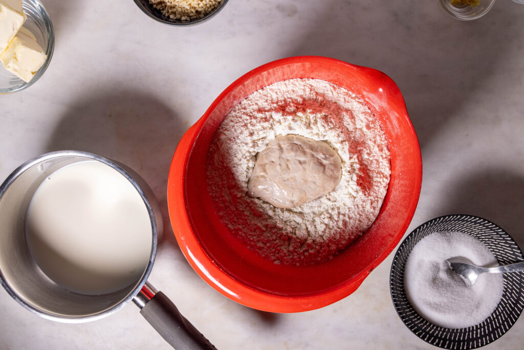 Hefe geht in einer Mulde im Mehl in einer Schüssel.