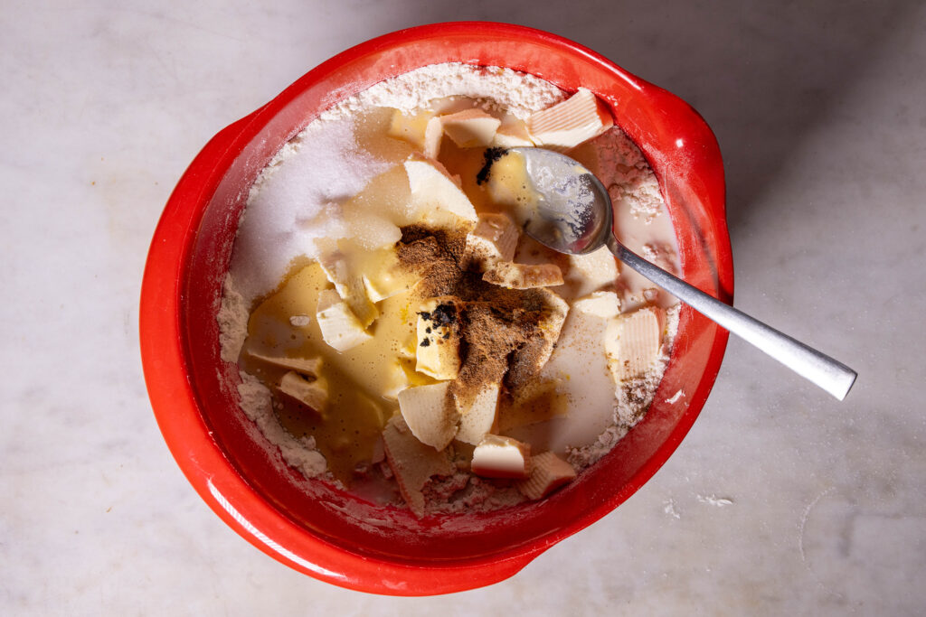 Ein Stollenreig wird zuberietet. Mehere Zuaten in einer Rührschüssel.