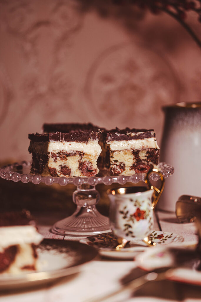 Vegane Donauwelle auf einer Etagere. Auf einem omahaft gedecktem Kuchentisch.