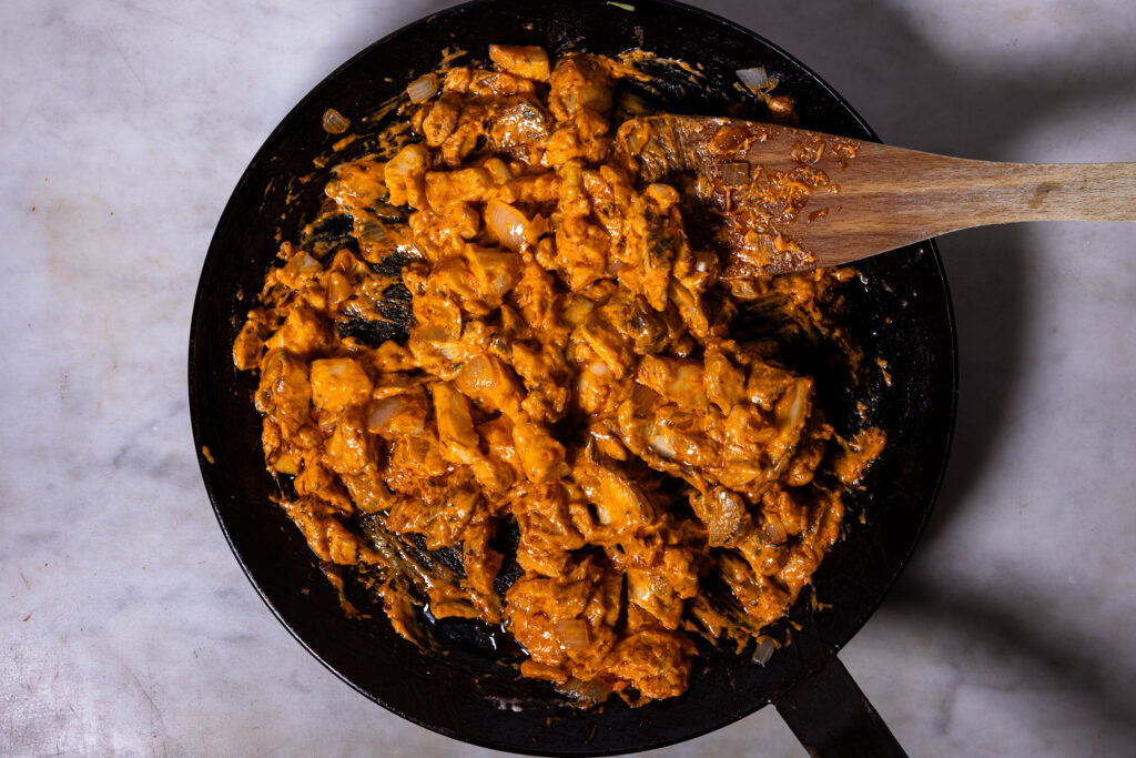 Eine cremige Pilzfüllung brät in einer Pfanne.