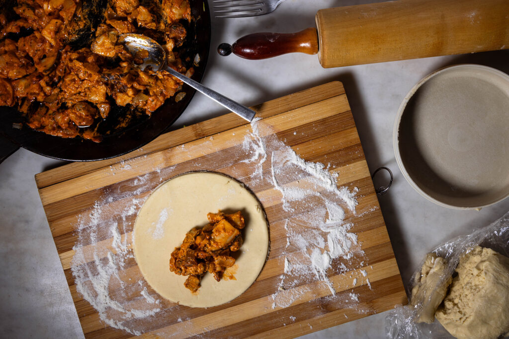 Ein Mürbeteig wird mit herzhafter Waldpilzfüllung belegt.