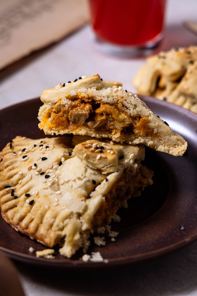 Angeschnittener Hand Pie mit Waldpilzfüllung auf einem Teller. Man sieht die cremige Füllung.