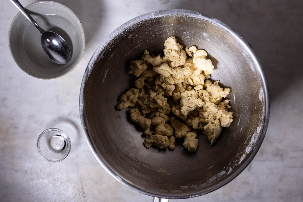 Veganer Mürbeteig wird zubereitet.Ein krümeliger Teig in einer Rührschüssel.