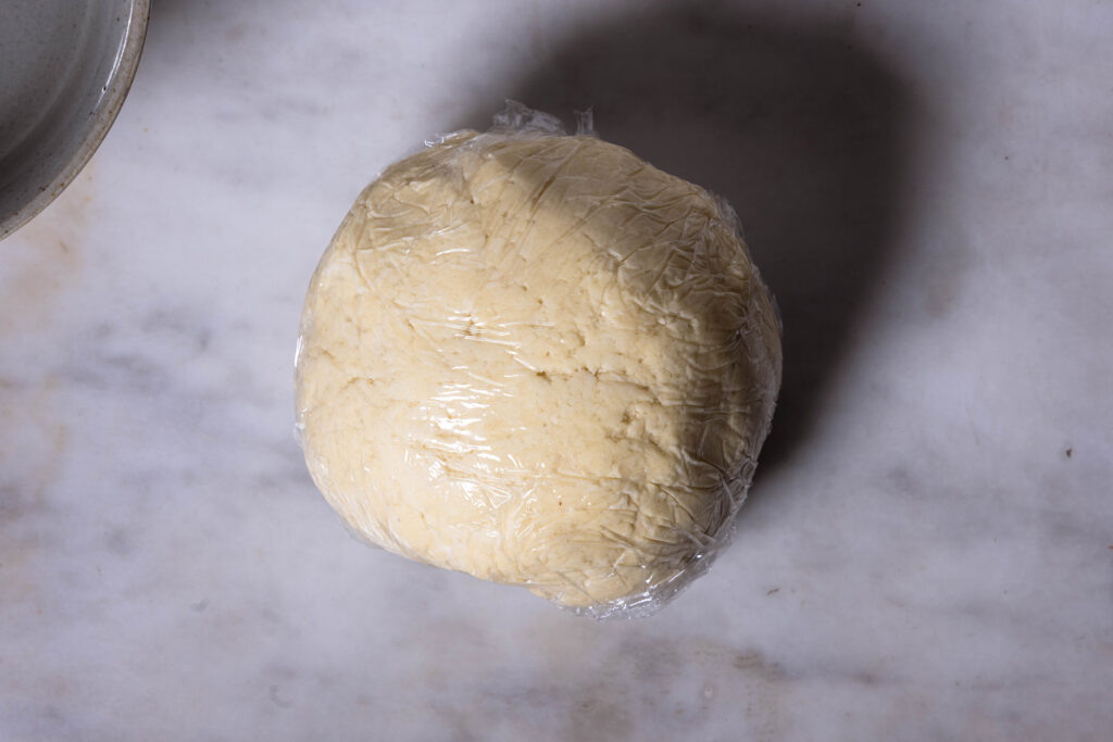 Veganer Mürbeteig, eingewickelt in Frischhaltefolie.