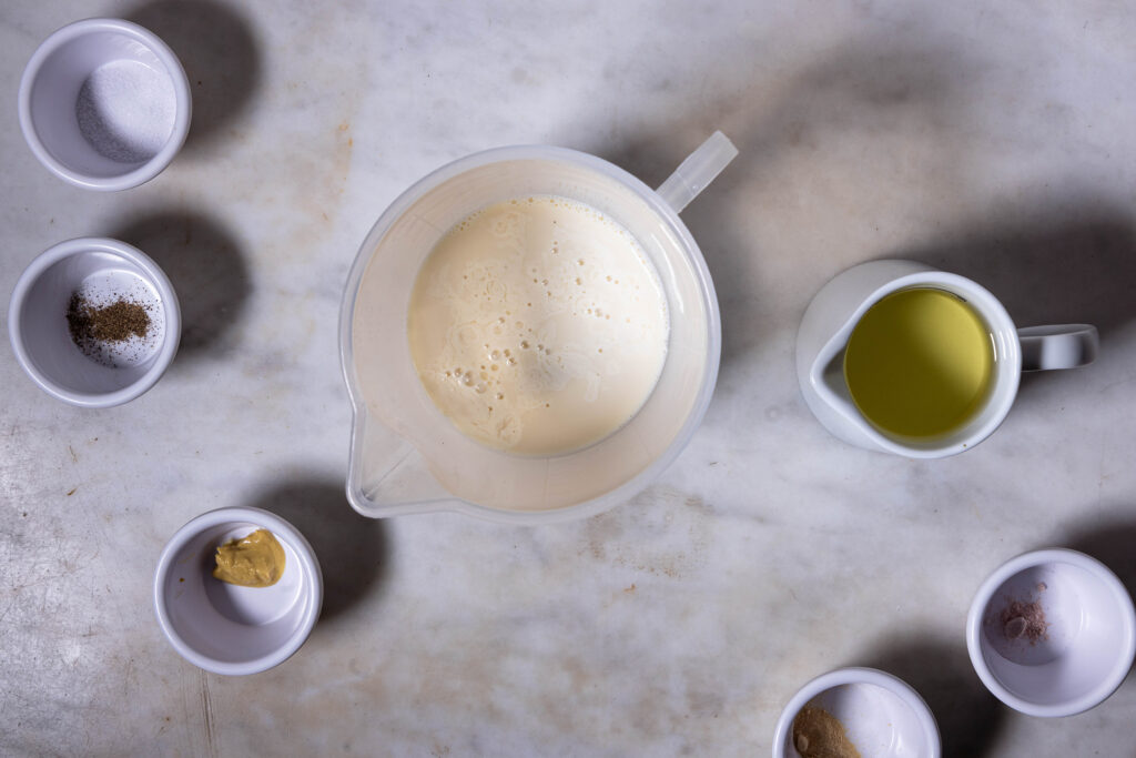 Zutaten für vegane Mayonnaise. In einem Messbecher stockt Sojamilch.