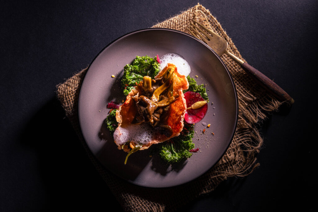 Minzluftals kleine Beilage auf einem Teller mit einem bunten, herzhaften Fine Dining Gericht.