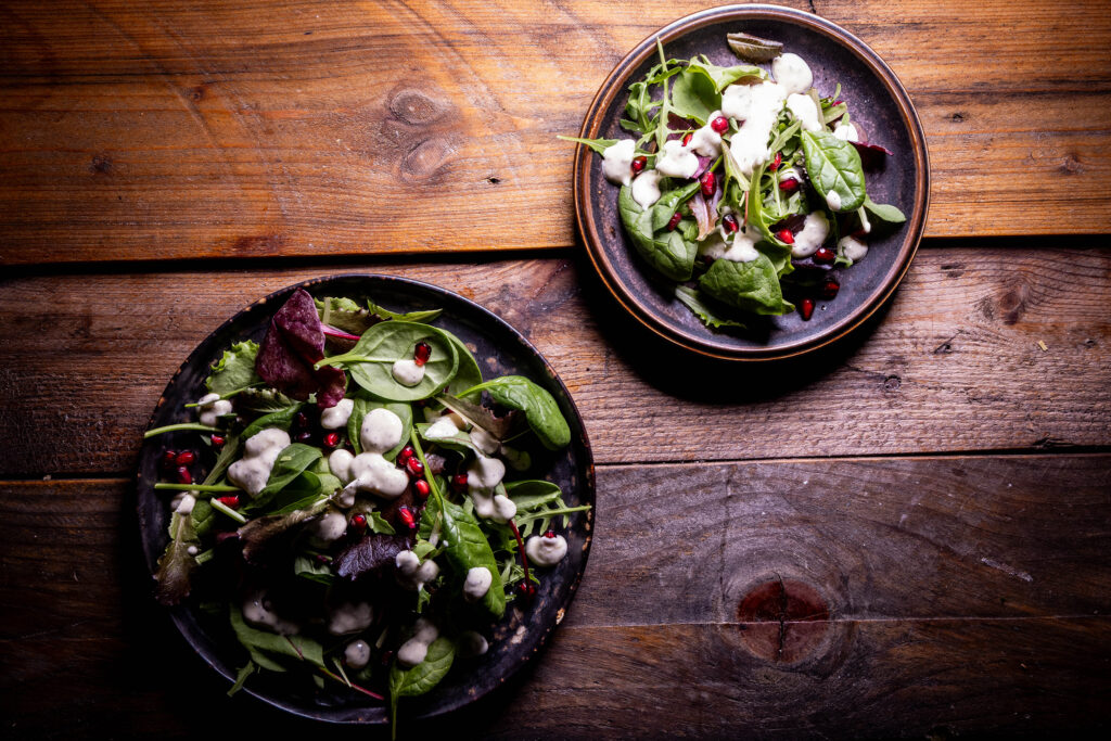 Zwei Salatteller mit Dressing.