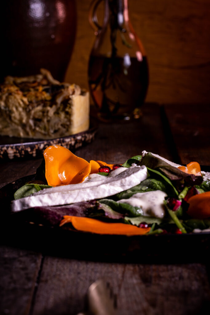 Orangebecherling-Salat mit Blumenbert und Granatapfelkernen.
