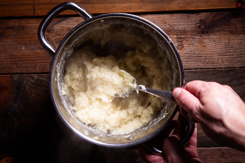 Hafersahne und Walnussöl werden unter ein Pastinakenpüree gehoben.