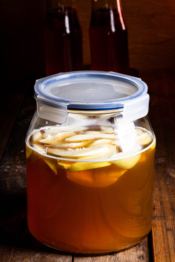Quittenkombucha reift in einem Gefäß.
