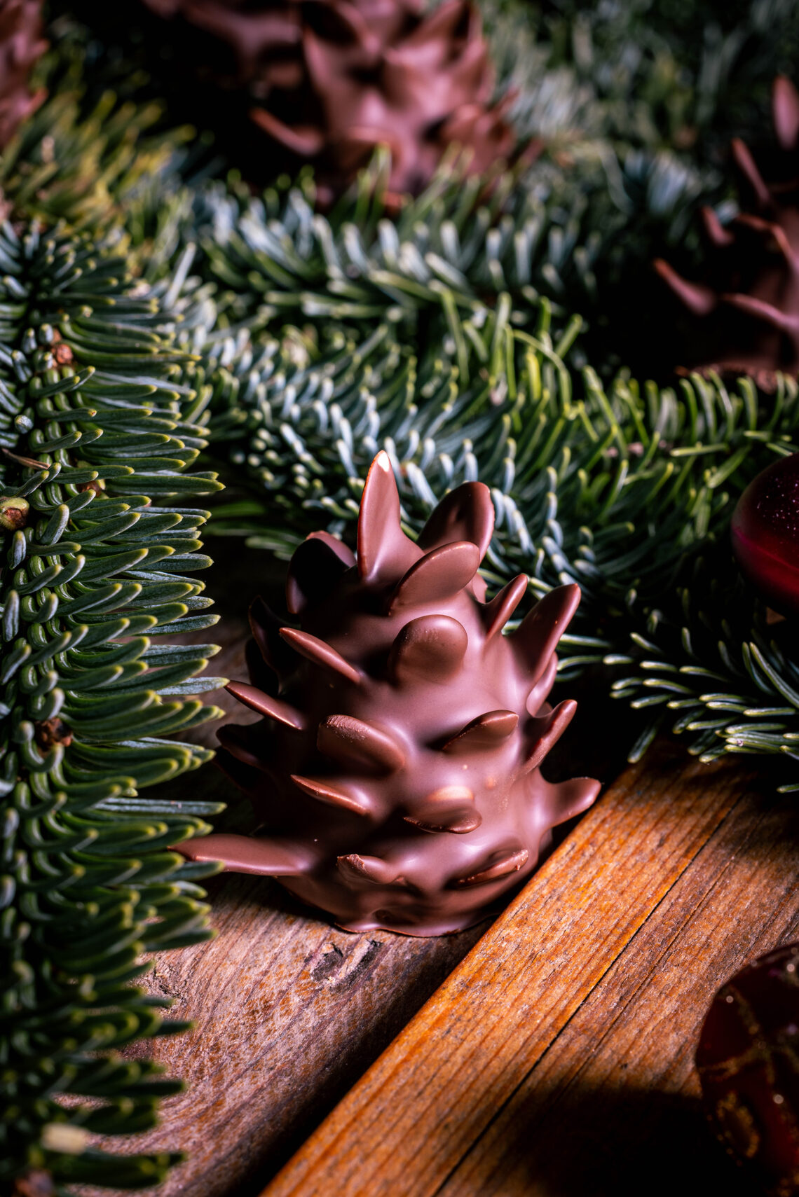 Schokozapfen - Marzipan-Tannenzapfen - dekorativ in Tannenzweigen platziert.