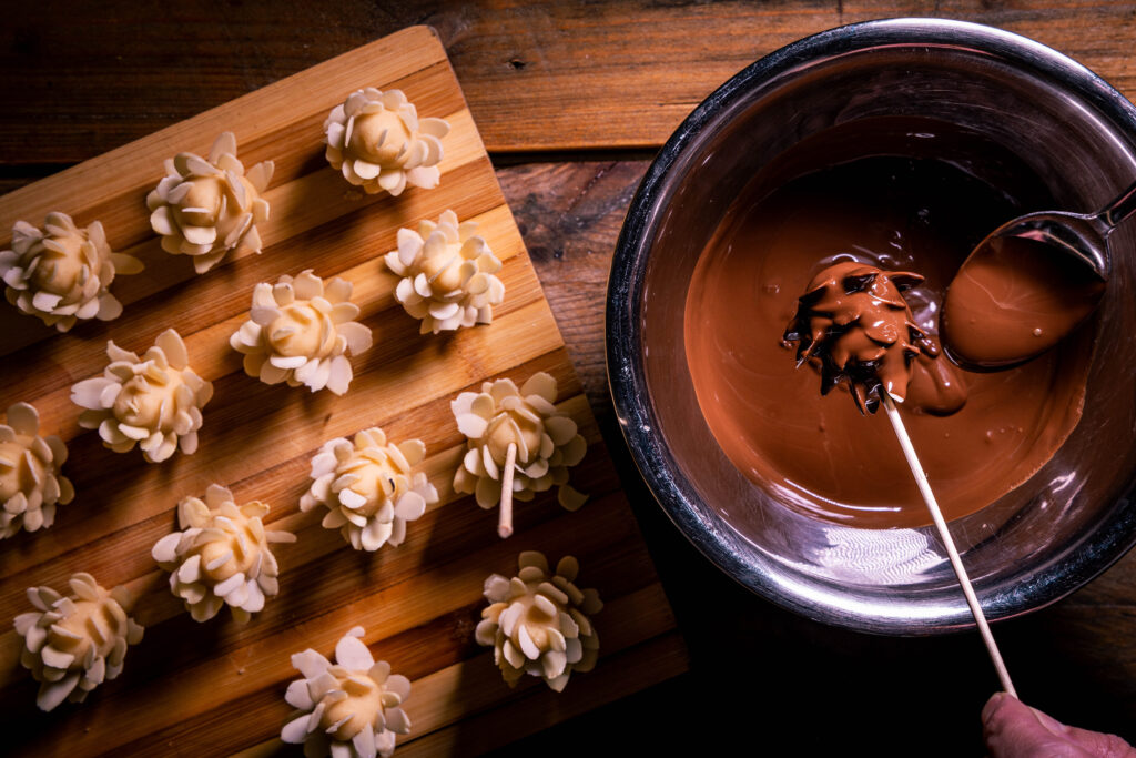 Schokozapfen werden mit Kuvertüre schokoliert.
