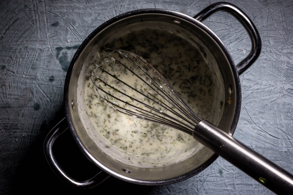 Eine Sauerampfersauce wird in einem Topf zubereitet.