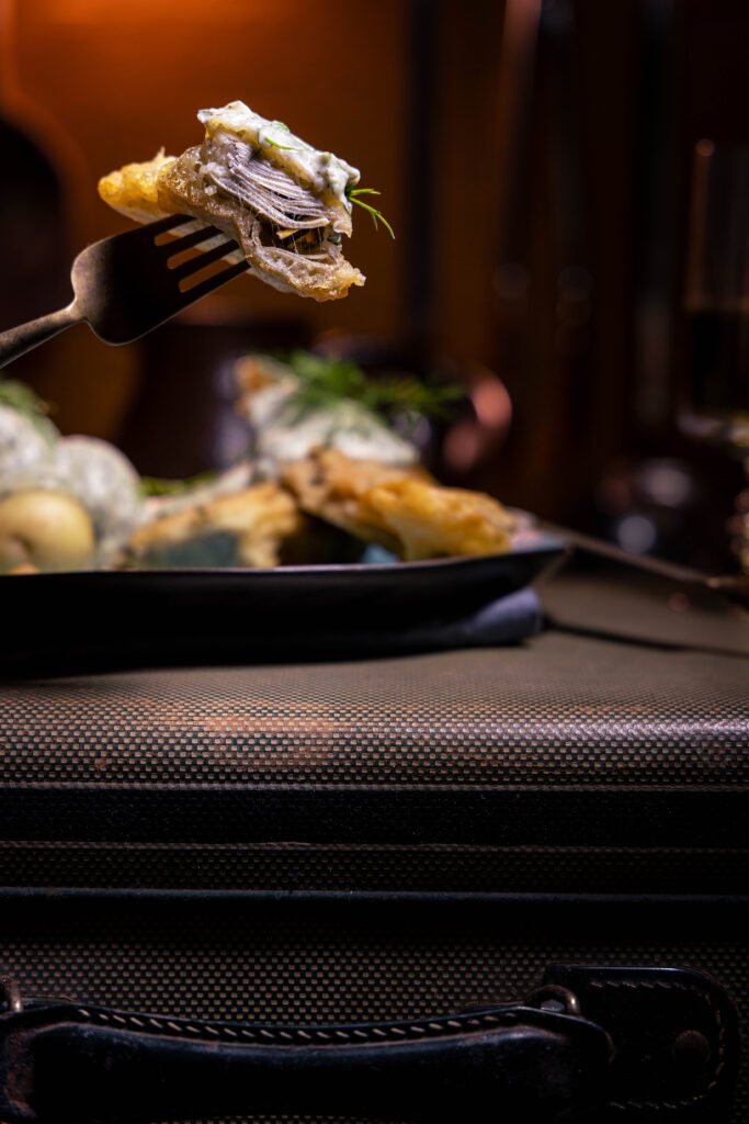 Mein köstlicher, veganer Backfisch aus Bananenblüten mit Dillsauce und Kartoffeln. Ein Stück Visch auf einer Gabel aufgespießt.